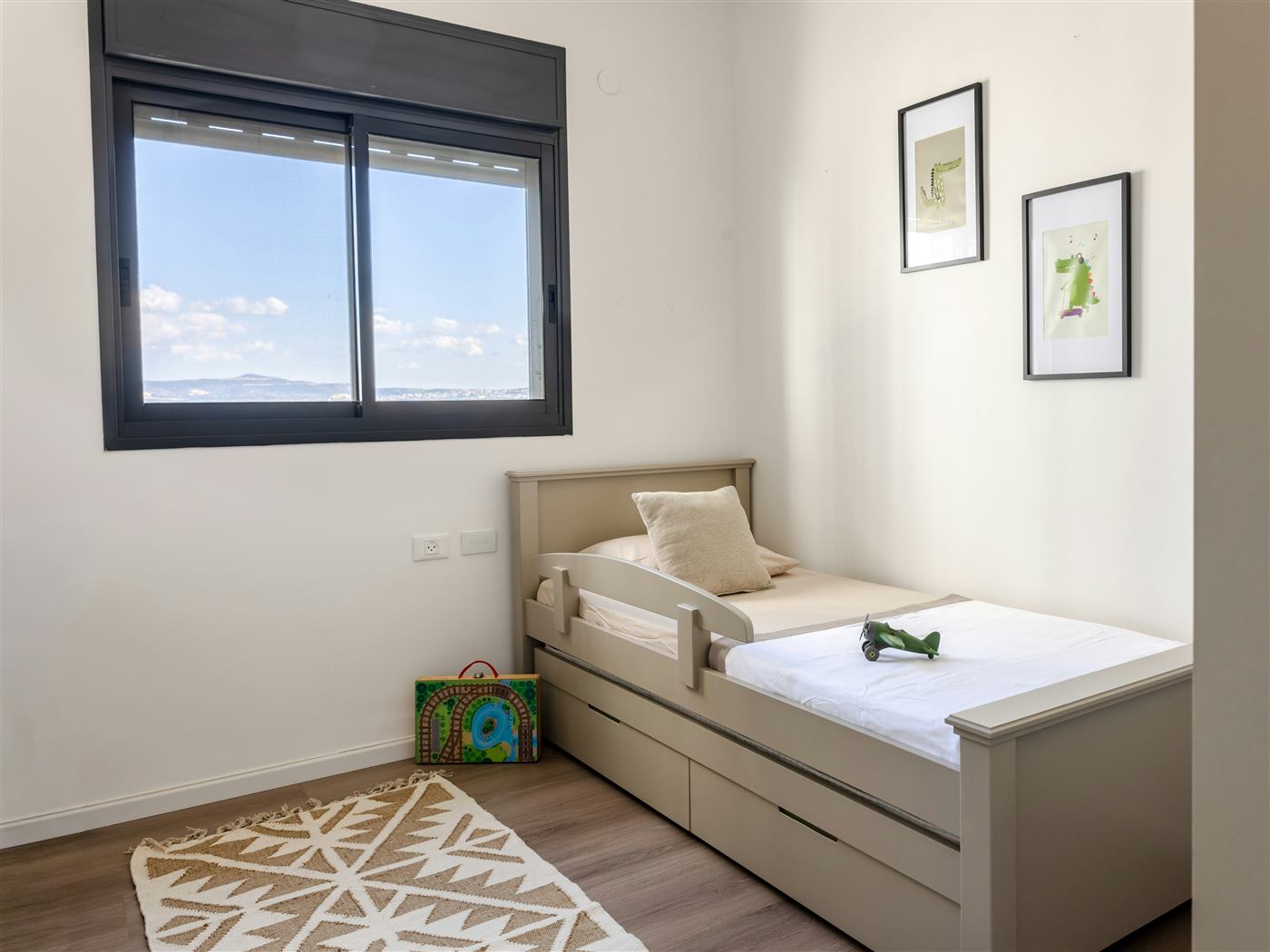 Single bed with built-in storage drawers underneath in a bright bedroom