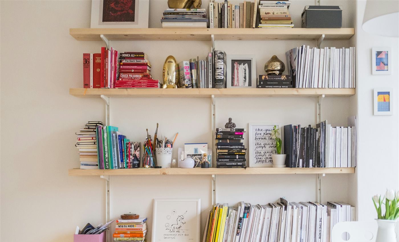 Wall-mounted wooden shelves holding books and decor